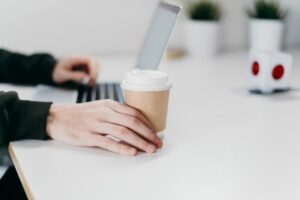 homem usando conta digital com computador e tomando cafe